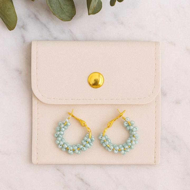 Cercei rotunzi aurii cu pietre albastre, cu plic din piele alb