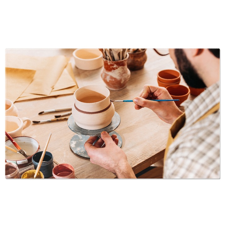 Tablou Canvas Arta Ceramicii Olarul Pictand O Ulcica Ceramica in Atelierul Sau, o Demonstrare a talentului si a Creativitatii Sale 40x25CM