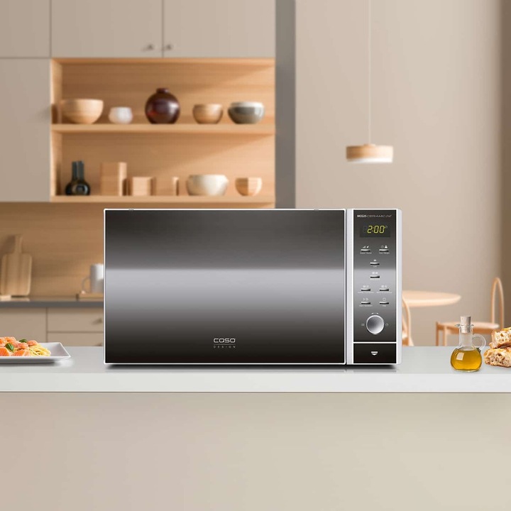 Cuptor cu microunde 3in1 Caso Germany, capacitate 25 litri, functie de grill, baza ceramica fara platou, gatire pe doua nivele, 10 trepte de putere, 9 programe pre-stabilite, timer 95 min, Child Lock, gatire uniforma, usa cu efect de oglinda, argintiu